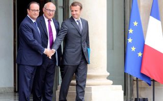 Ο Γάλλος πρόεδρος Φρανσουά Ολάντ δίνει το χέρι του στον μόλις 37χρονο νέο υπουργό Εθνικής Οικονομίας Εμανουέλ Μακρόν. Ανάμεσά τους ο υπουργός Οικονομικών της Γαλλίας Μισέλ Σαπέν.