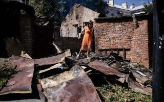 Γυναίκα ανάμεσα στα συντρίμμια μετά από τη ρίψη οβίδων στο Ντονέτσκ.