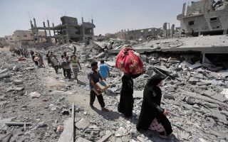 Παλαιστίνιοι κουβαλούν όσα υπάρχοντα διέσωσαν από τα κατεστραμμένα σπίτια τους στη Λωρίδα της Γάζας. Η 72ωρη εκεχειρία που τέθηκε σε εφαρμογή την Παρασκευή τινάχθηκε στον αέρα μετά την απαγωγή Ισραηλινού στρατιωτικού και τους βομβαρδισμούς στη Ράφα, με θύματα δεκάδες Παλαιστινίους.