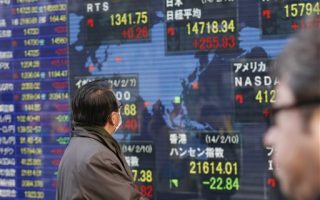 A man looks at an electronic stock indicator showing global stock prices including Japan's benchmark Nikkei 225, top center, which gained 255.93 points, or 1.77 percent, and closed at 14,718.34 in Tokyo Monday, Feb. 10, 2014. Asian stock markets were mostly higher Monday as investors looked ahead to Janet Yellen's first comments before Congress as the new Federal Reserve chairwoman. (AP Photo/Shizuo Kambayashi) (AP Photo/Shizuo Kambayashi)