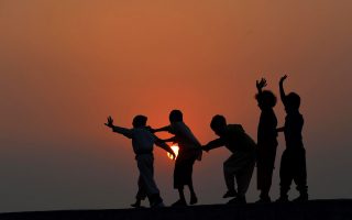 Τα παιδιά του Πακιστάν, στα προάστια της Λαχώρης χορεύουν στην οροφή ενός σπιτιού, στο ηλιοβασίλεμα. Η ημέρα είναι δική τους. (AFP PHOTO/Arif ALI)