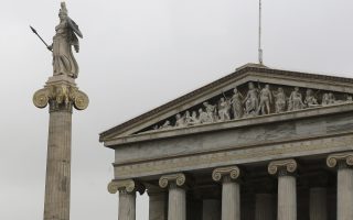 A man walks past  the Athens Academy with  the 19th century statue of the ancient goddess Athena, on Friday, March 27, 2015. Greek bank deposits dropped by more than 7.5 billion euros ($8.2 billion) in February, ramping up pressure on the country's teetering financial system as its government scrambles to reach a deal with creditors within days. (AP Photo/Petros Giannakouris)