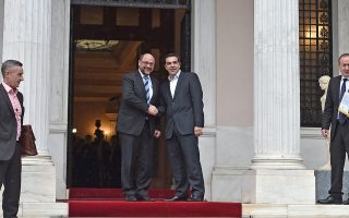 Greek Prime Minister Alexis Tsipras (R) shakes hands with European Parliament Chairman Martin Schulz as he welcomes him before their meeting in Athens on January 29, 2015. Greece will seek 