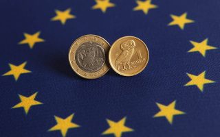 An one Euro (L) and one Greek Drachma coins are displayed on an European flag in this picture illustration taken in Istanbul June 14, 2012. On Sunday, Greece votes in an election where a radical left party that opposes the strict terms of the country's bailout could emerge victorious, increasing the chances of it abandoning the euro and returning to the drachma. REUTERS/Murad Sezer (TURKEY - Tags: POLITICS BUSINESS)