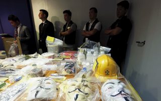 Police officers stand in front of Guy Fawkes masks seized along with explosives, during a news conference in Hong Kong, China June 15, 2015. Hong Kong police arrested nine people in raids and seized suspected explosives, authorities said on Monday, just days ahead of a contentious vote on how the Asia financial centre chooses its next leader in 2017.     REUTERS/Bobby Yip