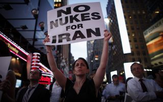 Μία γυναίκα που κρατά πόστερ κατά της ανάπτυξης πυρηνικής ενέργειας από το Ιράν συμμετέχει σε συγκέντρωση που πραγματοποιήθηκε στην πλατεία Τάιμς Σκουέρ της Νέας Υόρκης.