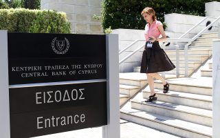 epa03315260 A woman emerges from the Central Bank of Cyprus in Nicosia, Cyprus, 23 July 2012. Officials from the IMF, the European Commission and the European Central Bank, collectively known as the “troika”, will have consultations there on Tuesday after Cyprus requested an international bailout to salvage its Greek exposed banks on 25 June.  EPA/KATIA CHRISTODOULOU
