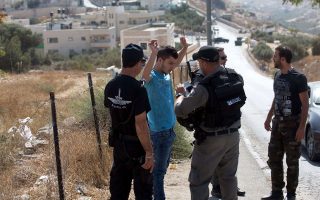 Ισραηλινοί αστυνομικοί ελέγχουν τα στοιχεία Παλαιστίνιου οδηγού έξω από την αποκλεισμένη συνοικία Τζαμπάλ Μουκάμπερ, στην Ανατολική Ιερουσαλήμ.