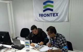In this photo taken on Saturday, Oct. 31, 2015, Frontex officer Francisco Ramos, left, and a colleague review data at a registration center run by the EU border protection agency at Moria on the island of Lesbos in southeastern Greece. The pilot program on Lesbos is aimed at speeding up registration of migrants and refugees amid a surge in the daily arrivals on Greek Islands. (AP Photo/Derek Gatopoulos)