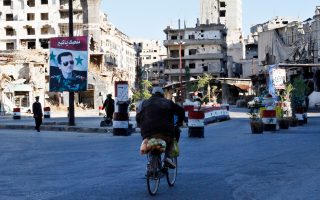 Ποδηλάτης πλησιάζει σημείο ελέγχου ανάμεσα στα ερείπια της παλαιάς πόλης της Χομς.