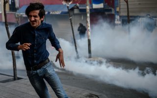 TOPSHOT - People run away from tear gas fired by Turkish anti-riot police on March 11, 2016 at Okmeyani district in Istanbul as people gather to mark the second anniversary of the death of the youngest victim of the Gezi Park protests.  Berkin Elvan was 14-years-old when he was hit by a police teargas cannister in Istanbul on June 16, 2013, as anti-government demonstrations swept Turkey.  / AFP / OZAN KOSE