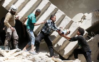 Στη φωτογραφία, άνδρες σωστικού συνεργείου και εθελοντές απομακρύνουν βρέφος από τα συντρίμμια βομβαρδισμένου κτιρίου σε περιοχή του Χαλεπίου που ελέγχεται από αντικαθεστωτικούς.