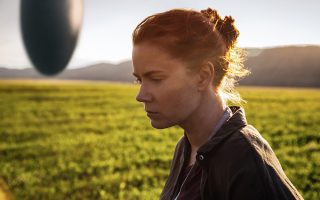 Η Εϊμι Ανταμς στην «Αφιξη» (Arrival), που αναμένεται στις κινηματογραφικές αίθουσες τον Νοέμβριο. Στο βάθος, ο ιπτάμενος δίσκος...
