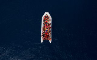 Refugees and migrants wait to be rescued by members of the Spanish NGO Proactiva Open Arms, after leaving Libya trying to reach European soil aboard an overcrowded rubber boat, north of Libyan coast, Sunday, May 6, 2018. In total 105 refugees and migrants from Bangladesh, Egypt, Nigeria, Marrocos, Gana, Pakistan, Sudan, Libya, Eritrea and Senegal were rescued in the overcrowded rubber boat. (AP Photo/Felipe Dana)