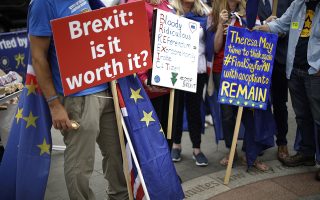 In this photo taken Wednesday, June 20, 2018, anti-Brexit, pro-EU supporters hold placards during a protest near the Houses of Parliament in London. The divisions opened up by the 2016 referendum have not healed, but hardened, splitting Britain into two camps: leavers and remainers. Almost the only thing the two groups share is pessimism about the way Brexit is going. (AP Photo/Matt Dunham)