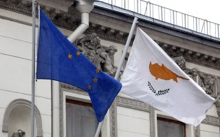 A Cypriot national flag, right, flies alongside a European Union flag outside the Cypriot embassy building in Moscow, Russia, on Thursday, March 21, 2013. Cyprus is offering Russia ÒopportunitiesÓ including banking and natural gas assets after lawmakers rejected a levy on bank deposits imposed by euro-area finance ministers, Finance Minister Michael Sarris said today in Moscow. Photographer: Alexander Zemlianichenko Jr/Bloomberg