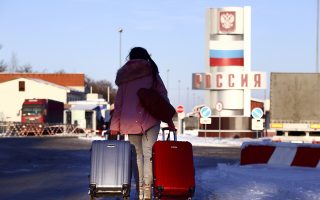 A woman prepares to cross the checkpoint at the border with Russia in Hoptivka, Ukraine, Friday, Nov. 30, 2018. Ukrainian officials announced earlier on Friday that all Russian men aged between 16 and 60 will be barred from entering Ukraine for the duration of the 30-day-long martial law. (AP Photo/Pavlo Pakhomenko)