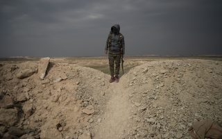 A U.S.-backed Syrian Democratic Forces (SDF) fighter stands atop a hill in the desert outside the village of Baghouz, Syria, Thursday, Feb. 14, 2019. U.S.-backed Syrian forces are clearing two villages in eastern Syria of remaining Islamic State militants who are hiding among the local population, and detaining others attempting to flee with the civilians, the U.S.-led coalition said Thursday. (AP Photo/Felipe Dana)