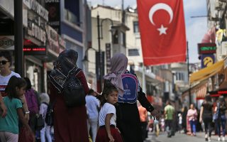 People walk at a market in Istanbul, Wednesday, Aug. 15, 2018. The Turkish lira currency has nosedived in value in the past week over concerns about Turkey's President Recep Tayyip Erdogan's economic policies and after the United States slapped sanctions on Turkey angered by the continued detention of an American pastor. (AP Photo/Lefteris Pitarakis)