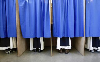 Monks from the Saint Sixtus Trappist Abbey cast their votes behind curtains at a polling station in Westvleteren, Belgium, Sunday, May 26, 2019. Belgium, which has one of the oldest compulsory voting systems, goes to the polls Sunday to vote on the regional, federal and European level. (AP Photo/Olivier Matthys)