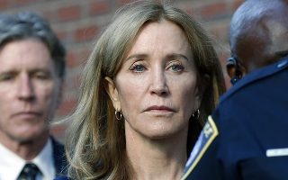 FILE - In this Sept. 13, 2019 file photo, actress Felicity Huffman leaves federal court in Boston with her brother Moore Huffman Jr., left, after she was sentenced in a nationwide college admissions bribery scandal. Huffman was sentenced to 14 days in federal prison in Dublin, Calif., but was released early Friday morning, Oct. 25,  after serving 10 days. (AP Photo/Michael Dwyer, File)