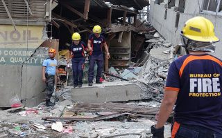 epa08073052 Firemen inspect a damaged market in the quake-hit town of Padada, Davao Del Sur province, Philippines, 15 December 2019. An earthquake of magnitude 6.8 shook the island of Mindanao in southern Philippines on December 12, a region in which there have been several deadly earthquakes in recent months.  EPA/CERILO EBRANO