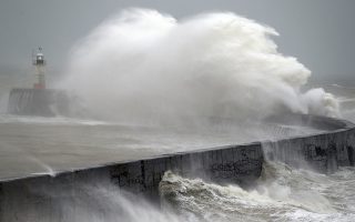 Waves crash into the wall at Newhaven south east England, as Storm Ciara, named by the Met Office national weather agency, hits the UK, Sunday Feb. 9, 2020. Trains, flights and ferries have been cancelled and weather warnings issued across the United Kingdom as a storm with hurricane-force winds up to 80 mph (129 kph) batters the region. (Andrew Matthews/PA via AP)