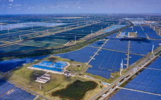 epa08743694 A photo made with a drone shows general view of the solar panels and wind turbines of Wind, Solar and Fishing Base in Dongtai near Yancheng, Jiangsu province, China, 14 October 2020. The largest integrated power station of 