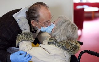 Bob Underhill, 84, and his wife Patricia, 82, suffering from Alzheimer's, kiss through a face mask as they are allowed to visit with physical contact for the first time at The Chiswick Nursing Centre, which has introduced a coronavirus disease (COVID-19) test with results ready in thirty minutes, in London, Britain December 2, 2020.  REUTERS/Kevin Coombs