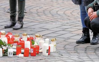 Γερμανοί πολίτες πενθούν αφήνοντας κεριά και λουλούδια στο σημείο της δολοφονικής επίθεσης (φωτ. EPA).

