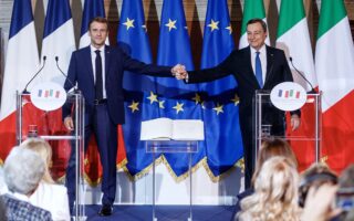 Ο Ιταλός πρωθυπουργός Μάριο Ντράγκι και ο Γάλλος πρόεδρος Εμανουέλ Μακρόν ενώνουν τα χέρια μετά την υπογραφή της «Σύμβασης του Κυρηναλίου». Τα μηνύματα από τη Ρώμη και το Βερολίνο είναι θετικά σε μια πολύ δύσκολη συγκυρία για την Ευρώπη. (EPA/ROBERTO MONALDO / POOL)