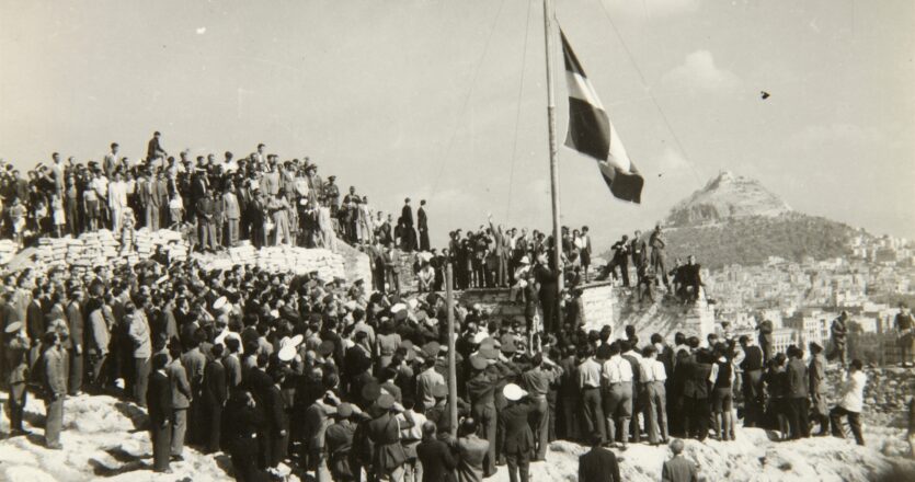 Ο Νίκος Αλιβιζάτος αρχίζει την εξιστόρησή του από το έτος γέννησής του, το 1949, πέντε χρόνια μετά την απελευθέρωση της Αθήνας από τις ναζιστικές δυνάμεις κατοχής. Στις 18 Οκτωβρίου 1944, ο Γεώργιος Παπανδρέου ύψωσε την ελληνική σημαία στην Ακρόπολη. (ΦΩΤΟΓΡΑΦΙΚΟ ΑΡΧΕΙΟ ΜΟΥΣΕΙΟΥ ΜΠΕΝΑΚΗ)