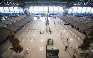 Ταξιδιώτες με προστατευτικές μάσκες μεταφέρουν τις αποσκευές τους στο άδειο αεροδρόμιο του Σαμούτ Πρακάν της Ταϊλάνδης. Πάνω από 8.200 πτήσεις σε όλο τον κόσμο ακυρώθηκαν λόγω της έξαρσης της «Ομικρον», που έχει μολύνει τα πληρώματα και έχει καταφέρει σοβαρό πλήγμα στις αερομεταφορές εν μέσω εορταστικής περιόδου. (φωτ. EPA / DIEGO AZUBEL)