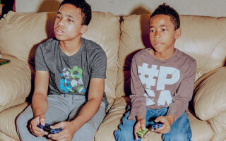 Τα αδέλφια Γκράιμς –ο 13χρονος Ντέιβιντ και ο 11χρονος Μάθιου– εξασκούνται στα e-sports μετακινούμενοι από τα γήπεδα μπάσκετ και ποδοσφαίρου προς τις κονσόλες PlayStation και Xbox. (Jake Dockins/The New York Times)