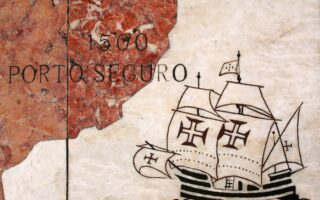 Καραβέλα φτάνει στο Πόρτο Σεγκούρο της Βραζιλίας το 1500. Λεπτομέρεια από μεγάλο μαρμάρινο «χάρτη» στο Μπελέμ της Λισσαβώνας, που απεικονίζει τις εξερευνητικές αποστολές των Πορτογάλων. Φωτ. SHUTTERSTOCK
