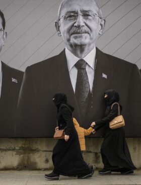 Δύο θρησκευόμενες γυναίκες με νικάμπ περνούν μπροστά από γιγαντοαφίσα που απεικονίζει τον επικεφαλής της αντιπολίτευσης, Κεμάλ Κιλιτσντάρογλου, ανάμεσα στους δημάρχους της Κωνσταντινούπολης και της Αγκυρας, Εκρέμ Ιμάμογλου (αριστερά) και Μανσούρ Γιαβάς... Φωτ. AP/Emrah Gurel