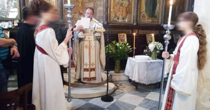 Ο πατέρας Αλέξανδρος έδωσε άδεια σε δύο 14χρονες κοπέλες να φορέσουν έξω από το ιερό τα «παπαδικά» και να κρατήσουν η καθεμιά από ένα κερί στη διάρκεια της ανάγνωσης του Ευαγγελίου, ανήμερα την Πεντηκοστή.